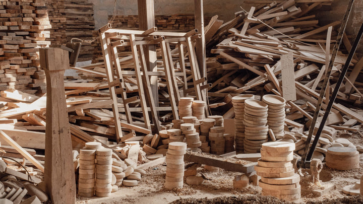 Stacked timber, frames and turned wooden discs on the Mâzia workshop floor